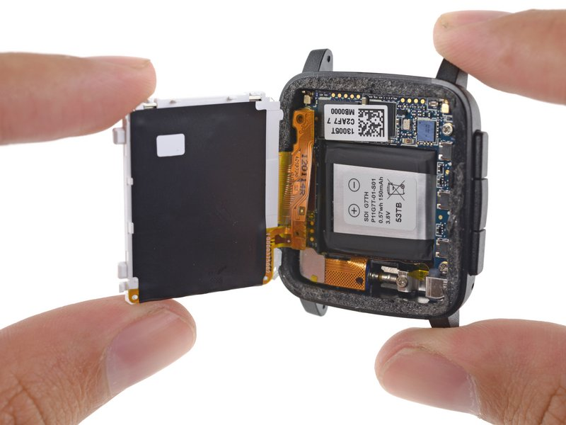 Imagem: Pebble Time aberto com o display levantado, expondo a bateria e a placa principal no interior do corpo.